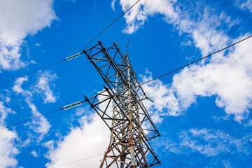 Old rusty High voltage power switchgear station, high voltage power line, line and insulated at sunny blue cloudy sky.