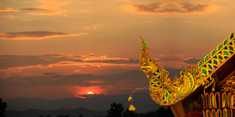 Beautiful golden naga and buddhist bells hanging on art roof of buddhist temple,Gable of the Thai...