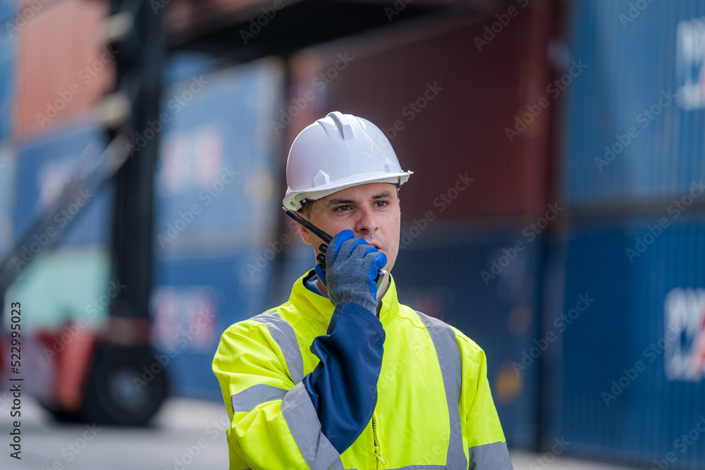 Poster Technicians using walkie talkie checking stock for loading in the container yard warehouse,Logistic shipping yard business.