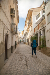 A tourist with child in the carrier walking on the desolated street in Alcalá del Júcar in Albacete province, Spain.