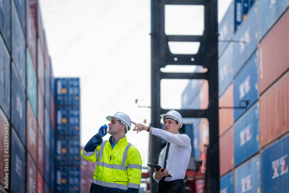 Poster Manager and Supervisor dock cargo checking and control loading Containers box at Container yard warehouse,Unity and teamwork concept.