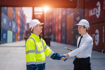 Businessman and Technician Shaking hands after the inspection are complete at the container yard warehouse.