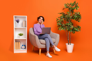 Full size photo of busy girl sit armchair speak telephone buy house interior isolated on orange color background