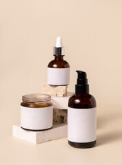 Cosmetic bottles on beige stones on light beige close up. Labels Mockup