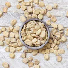 Bowl of raw dry Grass pea on wooden table top view. Legumes known in Italy as Cicerchia