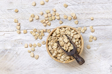 Bowl of raw dry Grass pea on wooden table top view. Legumes known in Italy as Cicerchia
