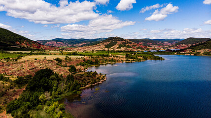 Vue aérienne du Lac du Salagou, occitanie, France. avec reflet saur l'eau et nuage sur un ciel bleu
