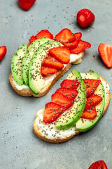 avocado toast with strawberries, soft cheese and chia seeds on a light background. healthy Breakfast or lunch. Keto diet. Food recipe background. Close up