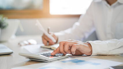 close up hands of accountant calculating tax refund using calculator