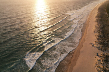 waves rolling towards white sand beach