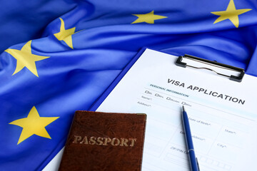 Visa application form for immigration, passport and pen on European Union flag, closeup