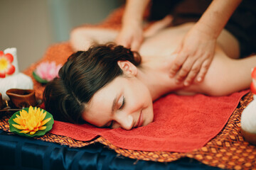 Obraz na płótnie Canvas Thai man making classical thai massage procedure to young woman at beauty spa salon