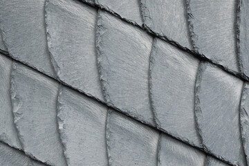 Detail close-up of natural grey stone shingle slate tiles texture roof abstract surface background....