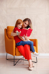 Mother reading a book to her little daughter