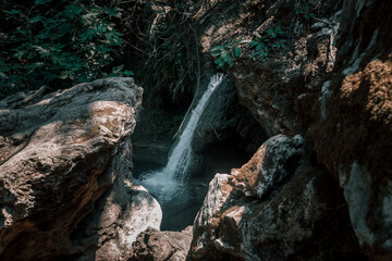 Beautiful waterfall in the forest. Cold water. Mountain river. Beautiful forest nature. Summer evening.