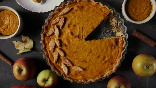 Thanksgiving Day. Pumpkin and pumpkin pie. Happy Thanksgiving wooden table. Pumpkin pie. Festive scene of autumn festival, fall. View from above. 4K