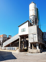 Obraz premium Concrete-mixing plant. Small concrete factory. Construction of a concrete plant on a sunny day under a blue sky