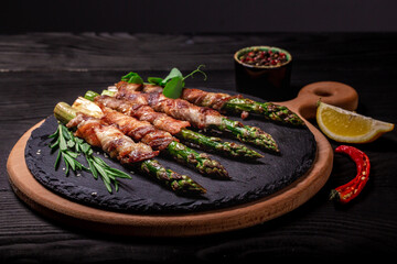 Grilled green asparagus wrapped with bacon. Ketogenic diet. Healthy food, diet menu. vertical image. top view. place for text
