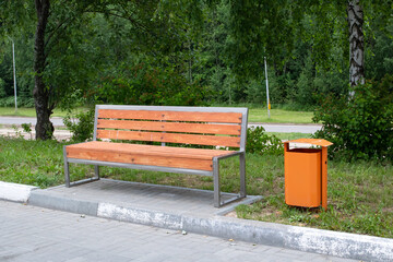 Wooden bench and garbage can in the park