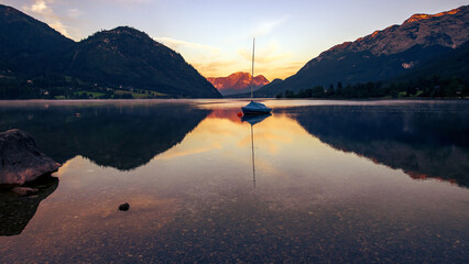 Ganz früh morgens am Grundlsee, Steiermark, Österreich...Boot auf spiegelnder Wasserfläche vor...