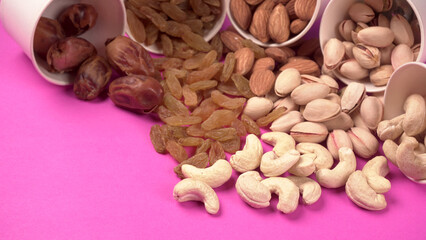 A variety mix of dried fruits and nuts on a pink background. Selective focus.Concept of Healthy fitness super food.