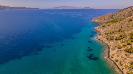 Fototapeta na wymiar Beautiful seashore. Islands in the distance. Colorful blue sea. The beauty of Turkey. Beautiful rocks and mountains. Sunny clear day. Beautiful water.