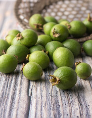wild guava fruits scattered on a wooden surface, freshly harvested common tropical fruits that packed with nutrients, soft-focus background with copy space