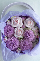 zephyr bouquet of flowers in a pink box on a light background, top view