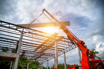 A mobile crane is lifting the PU metal sheet to a higher height to cover the factory roof.