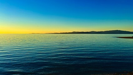 sunset on Ocean Calmness and silence is like a lake or sea on resting in trailers on the shore bright colors of dark blue orange stripe on the horizon from sun rich space for text travel advertising