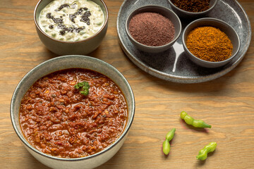 Sprouted Horse Gram Kurma (Korma) and Mogri Raita tempered with black mustard seeds. Also shown basic raita spices: black salt, indian mustard powder and roasted cumin.