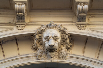 Beautiful stucco lion head decor on ancient building entrance porch in Montpellier, France