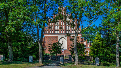 General view and architectural details of the Gothic Catholic Church of Saint John the Baptist built in the 16th century with a belfry in Gołymin in Masovia, Poland.