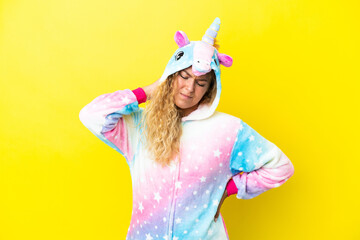 Girl with curly hair wearing a unicorn pajama isolated on yellow background with neckache