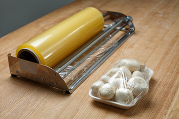 Close up of champignons on plastic tray packed in transparent cling film.