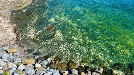 Green water and rocks visible at the ferry station that will sail from Danman Island to Vancouver Island Clear water to Emerald the water of the bay between vancouver and vancouver island