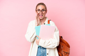 Young student caucasian woman isolated on pink background shouting with mouth wide open