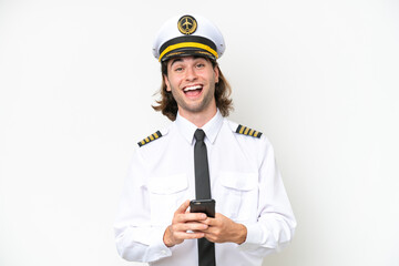 handsome Airplane pilot isolated on white background surprised and sending a message