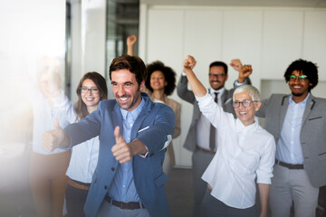 Happy group of business team celebrating a good job in the office. Business and finance concept.