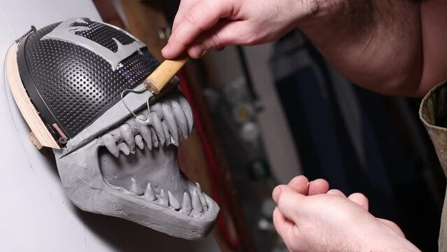 Artisan craftsman modeling mask based on plaster cast. Gypsum mold and plastic mask sculpting.