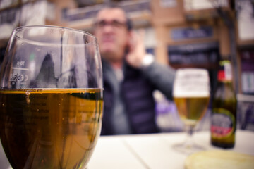 hombre tomando una cerveza en la terraza de un bar donde se enfoca la copa 