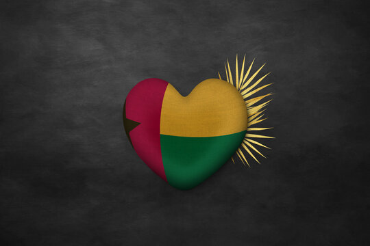 Textile heart in colors of national flag. Photography and marketing digital backdrop. Guinea- Bissau