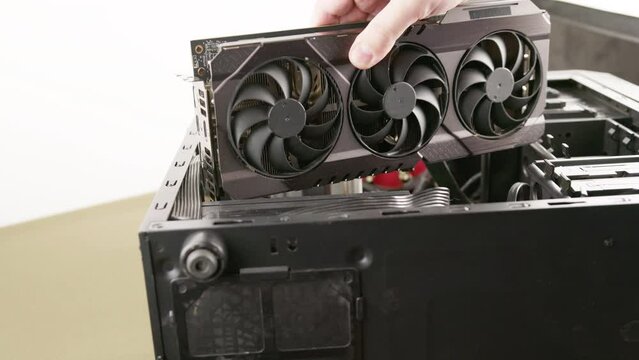 Caucasian Hand Trying To Fit A New Big Black Triple Fan Graphics Card Into Black Pc Case, Card Does Not Fit Because It Is Too Big