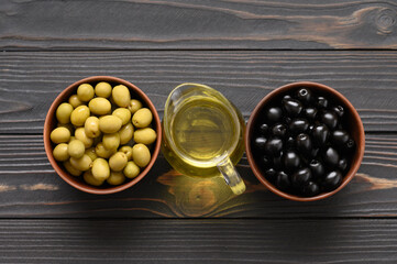Black and green olives on a dark wooden rustic background.