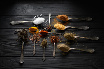 Colorful various herbs and spices for cooking on dark wooden rustic background