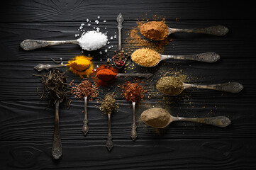 Colorful various herbs and spices for cooking on dark wooden rustic background