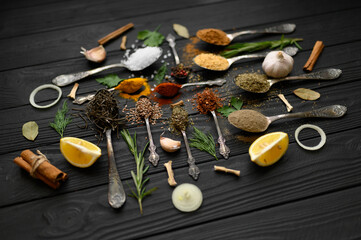 Colorful various herbs and spices for cooking on dark wooden rustic background