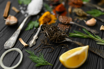 Colorful various herbs and spices for cooking on dark wooden rustic background