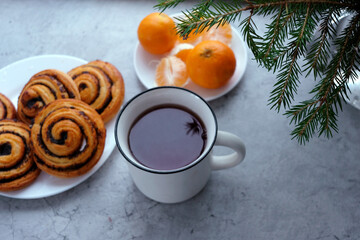 Obraz na płótnie Canvas christmas holidays food - tea cup, tangerine and poppy seed buns