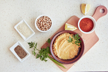 Creamy hummus with parsley and lemon. Paprika, roma seeds, chickpeas, sesame ingridients on the table. Healthy vegetarian natural rustic food. Top view food